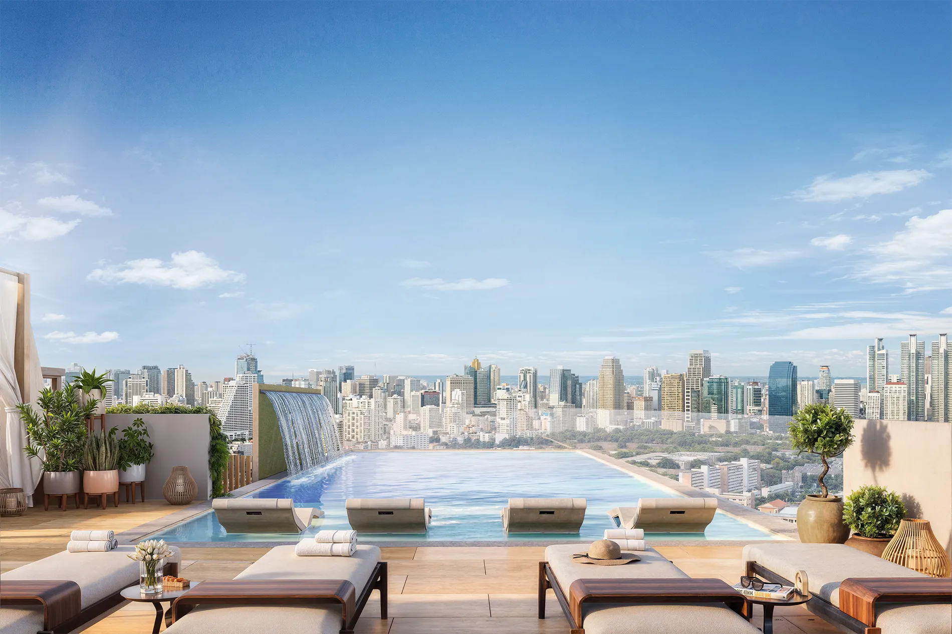 Rooftop pool with lounge chairs, potted plants, and a city skyline in the distance under a bright blue sky